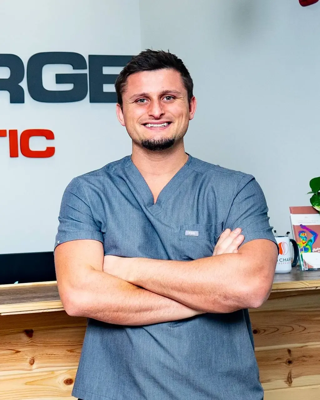 Dr. Palmer Piana, founder of Life Charge Chiropractic, in front of the office sign in Gallatin TN